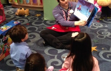 Tanayia reads a story to a group of children during storytime at Disney Store