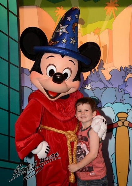 Disney Trip Traditions - Getting the perfect picture taken with Sorcerer Mickey is a tradition of ours. We have one from each trip!
